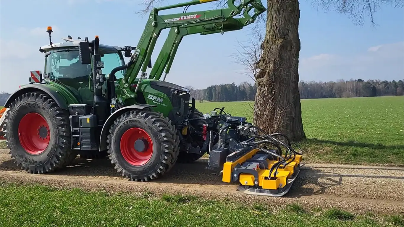 Fendt-Traktor mit Mulchkopf am Wegrand